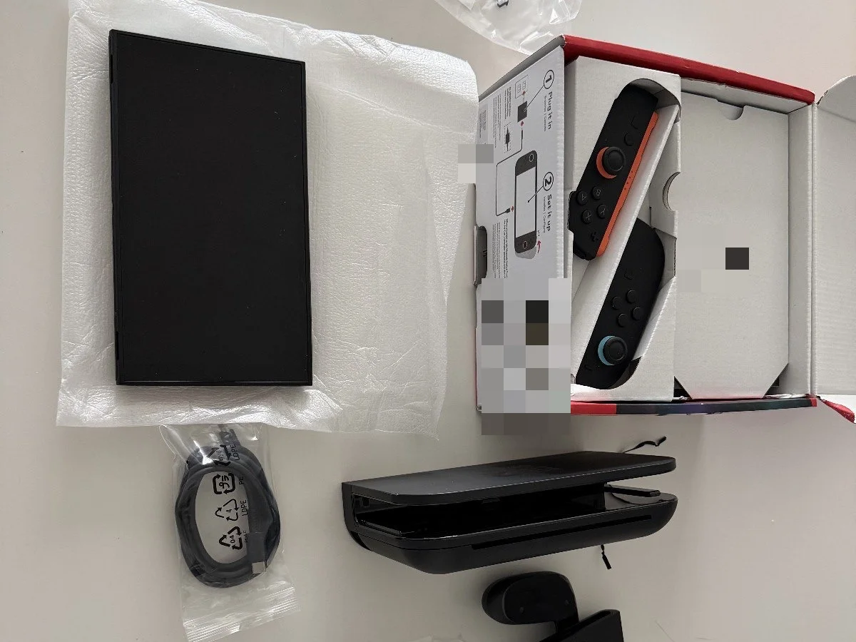 Nintendo Switch 2 console, dock, Joy-Con 2 controllers and cable laid out beside opened packaging.